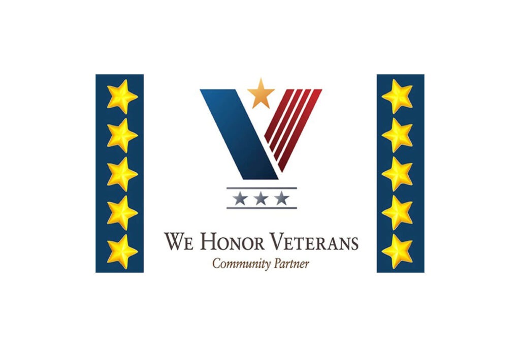 Logo for We Honor Veterans Community Partner featuring a large "V" with stripes and a star, flanked by columns of gold stars on each side.